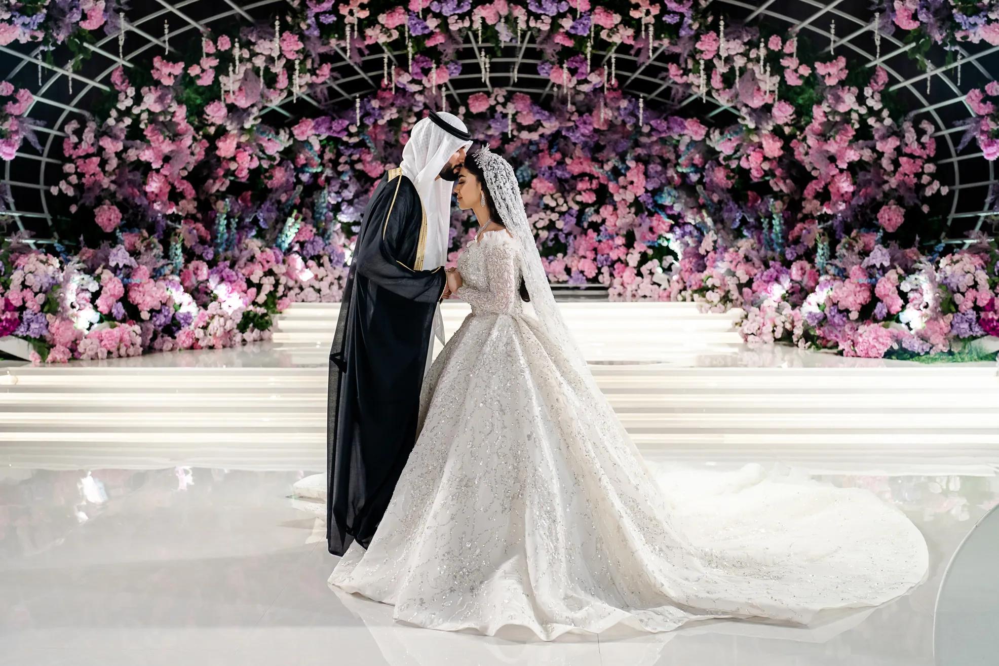 Luxury Arab wedding with abundant pink and purple floral installation